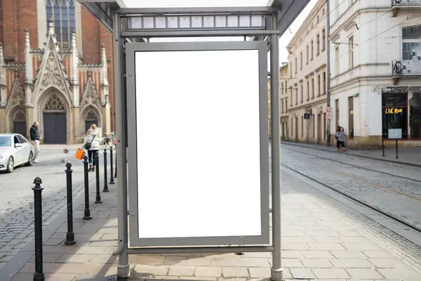 Krakow 'daki Boş Otobüs Durağı Reklam Çerçevesi. Krakow 'da kaldırımlı bir caddedeki modern bir otobüs durağında yüksek kaliteli fotograf boş reklam panosu duruyor. Boş çerçeve yeni bir reklam için hazır.