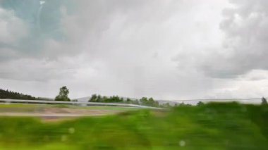 Çarpıcı bulutlu bir gökyüzünün altında yemyeşil bir vadiye bakan büyük, yükseltilmiş bir köprüyü geçiyoruz. Manzaralı ve karamsar seyahat görüntüleri ulaşım, altyapı ve hava durumu için mükemmeldir.