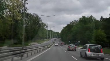 Bulutlu bir günde yeşil ormanda otoyol gezintisi. Sakin trafik sahnelerini, ağaçlık yolları ve huzurlu bir yolculuk atmosferini izleyin. Seyahat vlogları, rahatlama, arka plan görselleri veya
