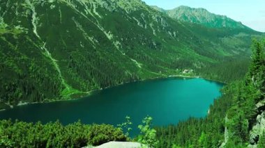 Güney Polonya 'daki Tatra Dağları ile çevrili Morskie Oko Gölü' nün çarpıcı hava manzarası. Kristal berrak mavi su, yemyeşil orman ve görkemli tepeler nefes kesici bir doğal manzara yaratır.