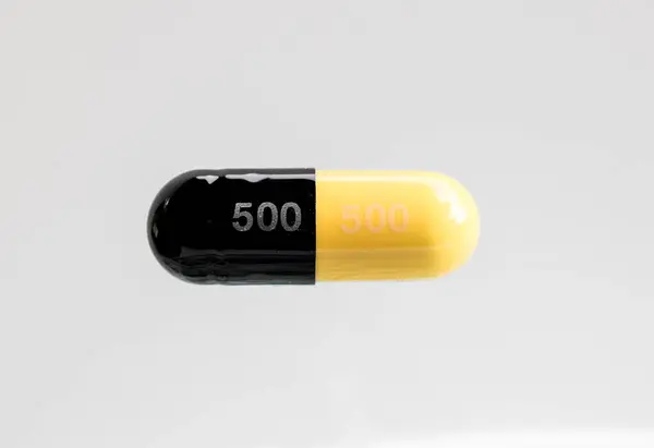 Cápsula Medicamento Negro Amarillo Sobre Fondo Blanco — Foto de Stock