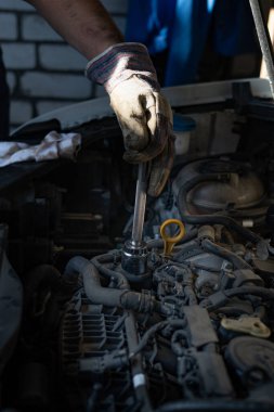 Tamirci kaputun altındaki arabayı tamir ediyor. Yüksek kalite fotoğraf