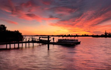 Gökyüzü ve bulutlarla gölün üzerinde gün batımı