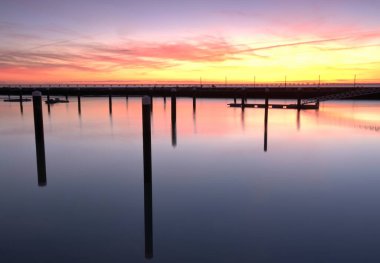 Sakin denizin üzerinde teknelerle güzel bir gün doğumu