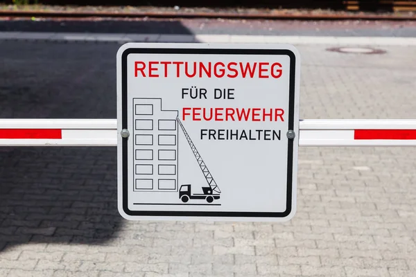 picture of a barrier with a German sign, that means keep the escape route clear for the fire department