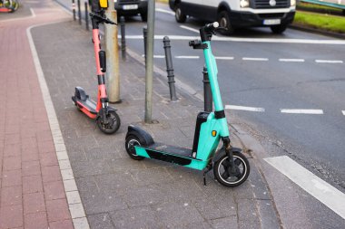 two e-scooter parking at the side of a city road