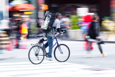 picture with camera made motion blur of a bicycle messenger on the move in the city