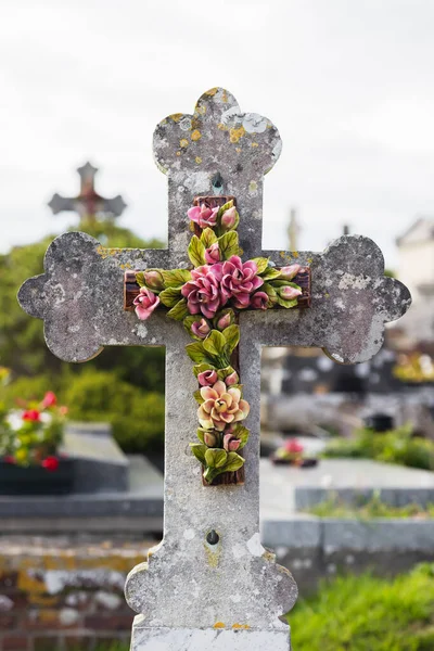 墓碑上装饰着陶瓷花的古老石制十字架 — 图库照片