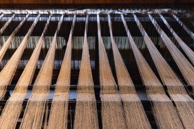 Detail shot of an antique weaving machine with woolen threads attached