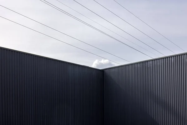 Angolo Edificio Industriale Ferro Ondulato Linee Elettriche Contro Cielo — Foto Stock