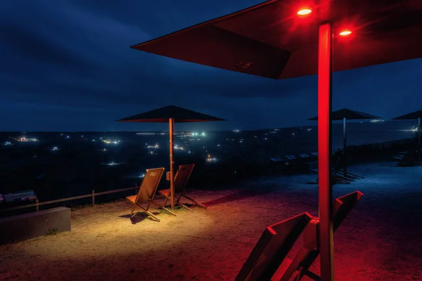 picture at night with umbrellas at the viewpoint of the Hambach brown coal mine, in Elsdorf, Germany