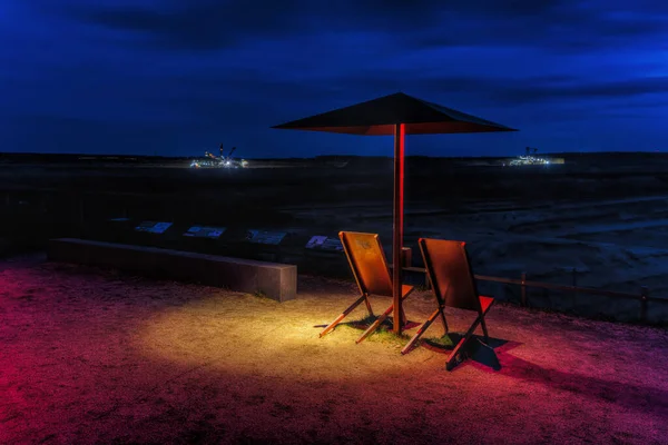 picture at night with umbrellas at the viewpoint of the Hambach brown coal mine, in Elsdorf, Germany
