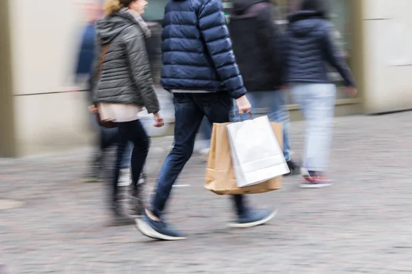 图片中一对购物夫妇在一个城市的行人区散步时的动作模糊 — 图库照片