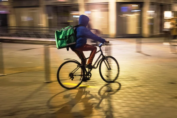 照片上 一个年轻的骑车人从送货处开车出去 晚上在城里转悠 弄得他神智不清 — 图库照片