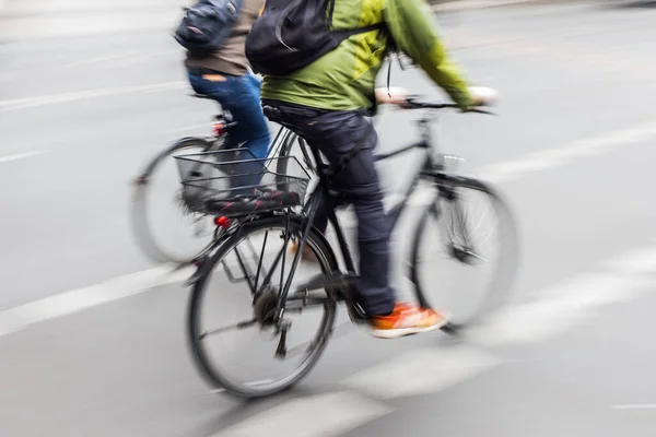 两个骑自行车的人在城市街道上的照片被照相机弄得模糊不清 — 图库照片