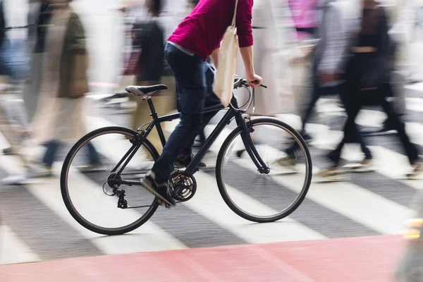 一个骑自行车的人在斑马线上穿过拥挤的街道时的照片 — 图库照片
