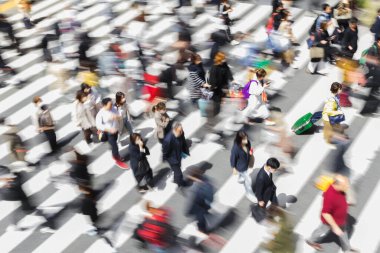 Tokyo, Japonya 'da bir zebra geçidinde şehir caddesinden geçen kalabalığın kasıtlı hareket bulanıklığı.