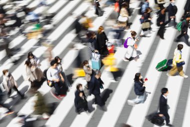 Tokyo, Japonya 'da bir zebra geçidinde şehir caddesinden geçen kalabalığın kasıtlı hareket bulanıklığı.