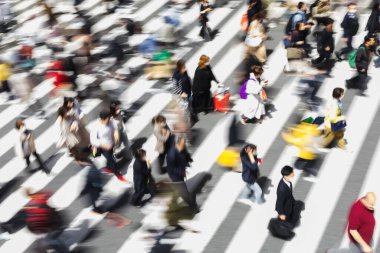 Tokyo, Japonya 'da bir zebra geçidinde şehir caddesinden geçen kalabalığın kasıtlı hareket bulanıklığı.