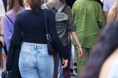 Kalabalığın arasında yürüyen kadınların arka plan görüntüsü.