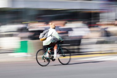 Genç bir adamın kasıtlı olarak şehir caddesinde bisiklet sürerken görüntüsü bulanıklaşır.