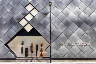 Tokyo, Japonya - 12 Nisan 2023: Bottega Veneta markasının vitrinli ve harfli modern mağaza cephesi. Bottega Veneta İtalya 'nın Milano şehrinde bulunan lüks bir İtalyan moda evi.