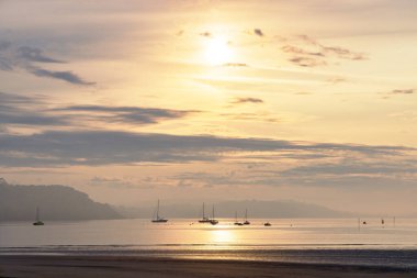 Fransa 'nın Crozon körfezindeki Atlantik Okyanusu üzerinde güneşin doğuşunun resmi.