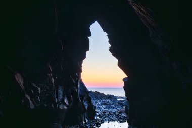 Crozon yarımadasında, Brittany Fransa 'da gün batımının olduğu bir mağaradan denize bakın.