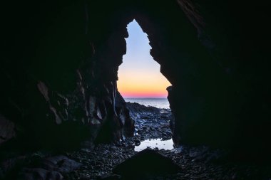 Crozon yarımadasında, Brittany Fransa 'da gün batımının olduğu bir mağaradan denize bakın.