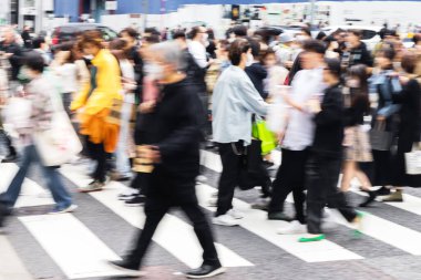 Tokyo, Japonya 'da bir caddeden karşıya geçen kalabalığın kasıtlı hareket bulanıklığı etkisi