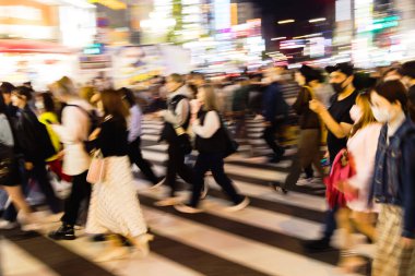 Tokyo, Japonya 'da gece vakti bir şehir caddesinden geçen kalabalığın kasıtlı hareket bulanıklığı