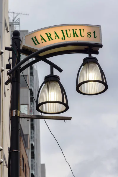 street sign of Harajuku Street with illuminated street lamps in Tokyo, Japan