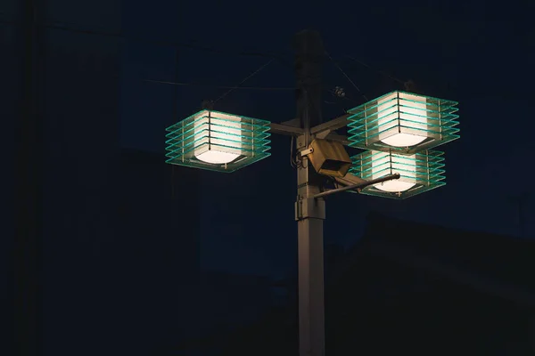 picture of an illuminated street lamp at night in a city