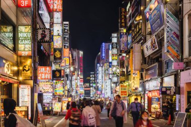 Tokyo, Japonya - 11 Nisan 2023: Kabukicho 'da birçok neon ışıklı sokak geceleri kimliği belirsiz insanlarla. Kabukicho, Shinjuku 'da birçok sinema salonu, hostes kulübü ve aşk otelleri olan ünlü bir eğlence merkezidir.