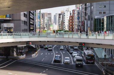 Tokyo, Japonya - 11 Nisan 2023: Shibuya 'daki yaya üstgeçitleri ile kimliği belirsiz insanların kesiştiği yer. Shibuya büyük bir ticaret ve finans merkezidir.