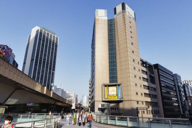 Tokyo, Japonya - 11 Nisan 2023: Shibuya 'daki yaya üstgeçitleri, kimliği belirsiz insanlarla dolu. Shibuya büyük bir ticaret ve finans merkezidir.
