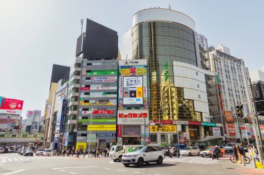 Tokyo, Japonya - 11 Nisan 2023: Shibuya 'da kimliği belirsiz insanların bulunduğu ticari binalarla kesişme noktası. Shibuya büyük bir ticaret ve finans merkezidir.