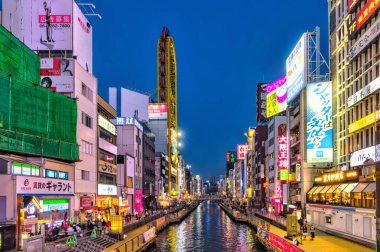 Osaka, Japonya - 13 Nisan 2023: Dotonbori Kanalı 'nda gece. Osaka 'nın başlıca turistik ve gece hayatı alanlarından biri olarak bilinen bölge, Dotonbori kanalı boyunca uzanır.