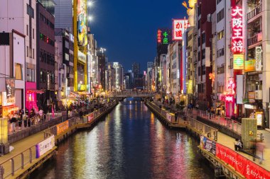 Osaka, Japonya - 13 Nisan 2023: Dotonbori Kanalı 'nda gece. Osaka 'nın başlıca turistik ve gece hayatı alanlarından biri olarak bilinen bölge, Dotonbori kanalı boyunca uzanır.