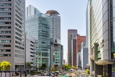 Osaka, Japonya - 12 Nisan 2023: Umeda, Osaka 'da yüksek binalarla sokak manzarası. Umeda, Kita-ku bölgesinde birçok otel ve ofis binası bulunan ticari ve ticari bir bölgedir.