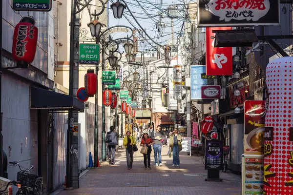 Osaka, Japonya - 13 Nisan 2023: Osaka 'nın kalabalık şehir merkezinde, bilinmeyen insanlarla dolu bir ara sokak. Osaka, Japonya 'nın en kalabalık üçüncü şehridir.