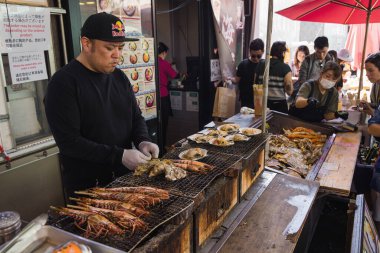 Tokyo, Japan - April 12, 2023: street food stall on Tsukiji Fish Market with unidentified people. It is a major tourist attraction. Before 2018, it was the largest wholesale fish market in the world clipart