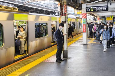 Tokyo, Japonya - 10 Nisan 2023: Tokyo 'da kimliği belirsiz insanlarla dolu bir tren istasyonunda olay yeri. Tokyo, demiryolu ve kara taşımacılığı için Japonya 'nın en büyük iç ve uluslararası merkezidir.