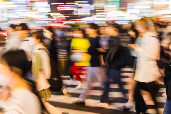 abstract photo of a crowd of people crossing a street in the big city at night