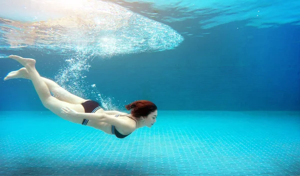 swimming asian woman underwater on swimming pool