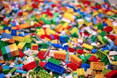 Arka plan için izole edilmiş çeşitli renkli plastik oyuncak tuğlaları yığını. Eğitim konsepti için tasarım ve inşaat becerisi öğrenme ve yapma