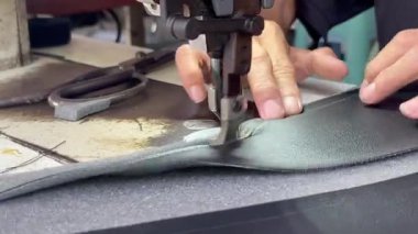 Yakın çekim insan eli, araba koltuğu için süngerle deri dikiyor.