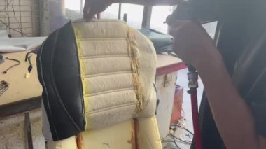 Yavaş çekimde tutkal araba koltuğu yastığına yapıştırıcı sıkarak tamir sürecinde