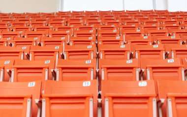 Boş bir stadyumda turuncu spor koltuğu tribünü..