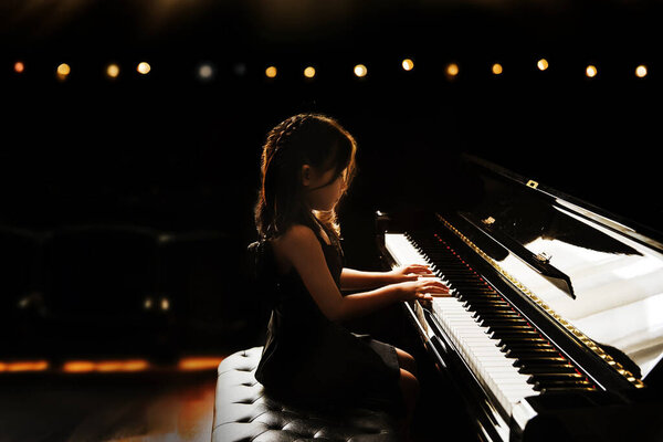 Азиатская девочка дети перформанс играть на фортепиано в классической музыки способность на сцене